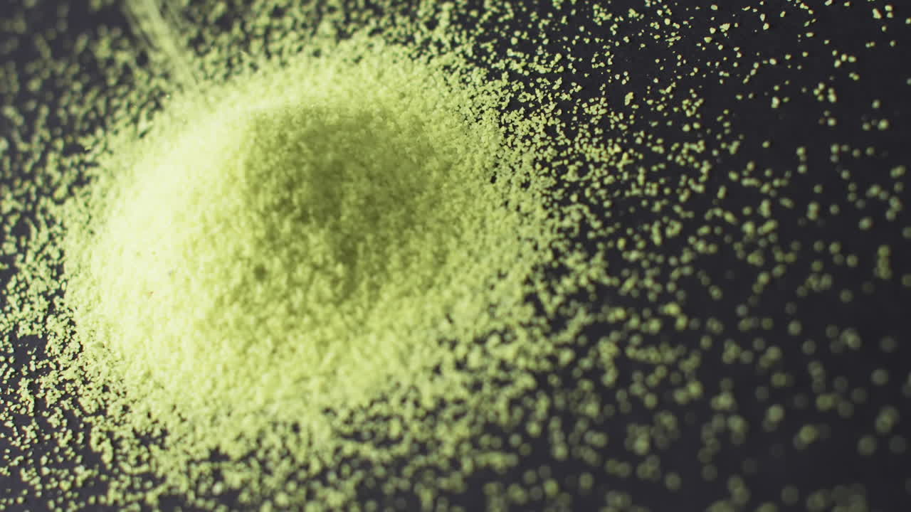 녹색 모래  ⁇ 어리가  ⁇ 어지고 검은색 배경에 있는 공간을 복사하는 클로즈업 비디오