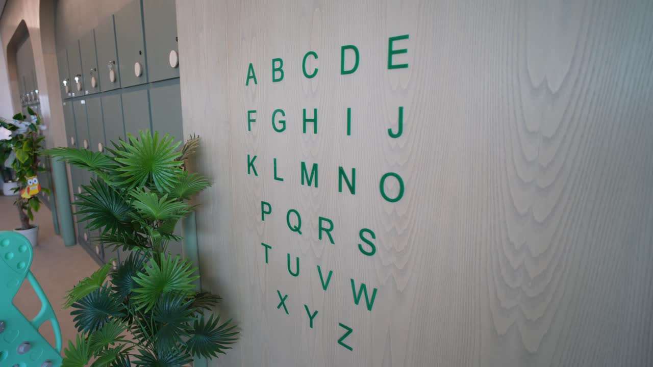 Shot of alphabets printed on white wall at Kids Day Care in Pakistan
