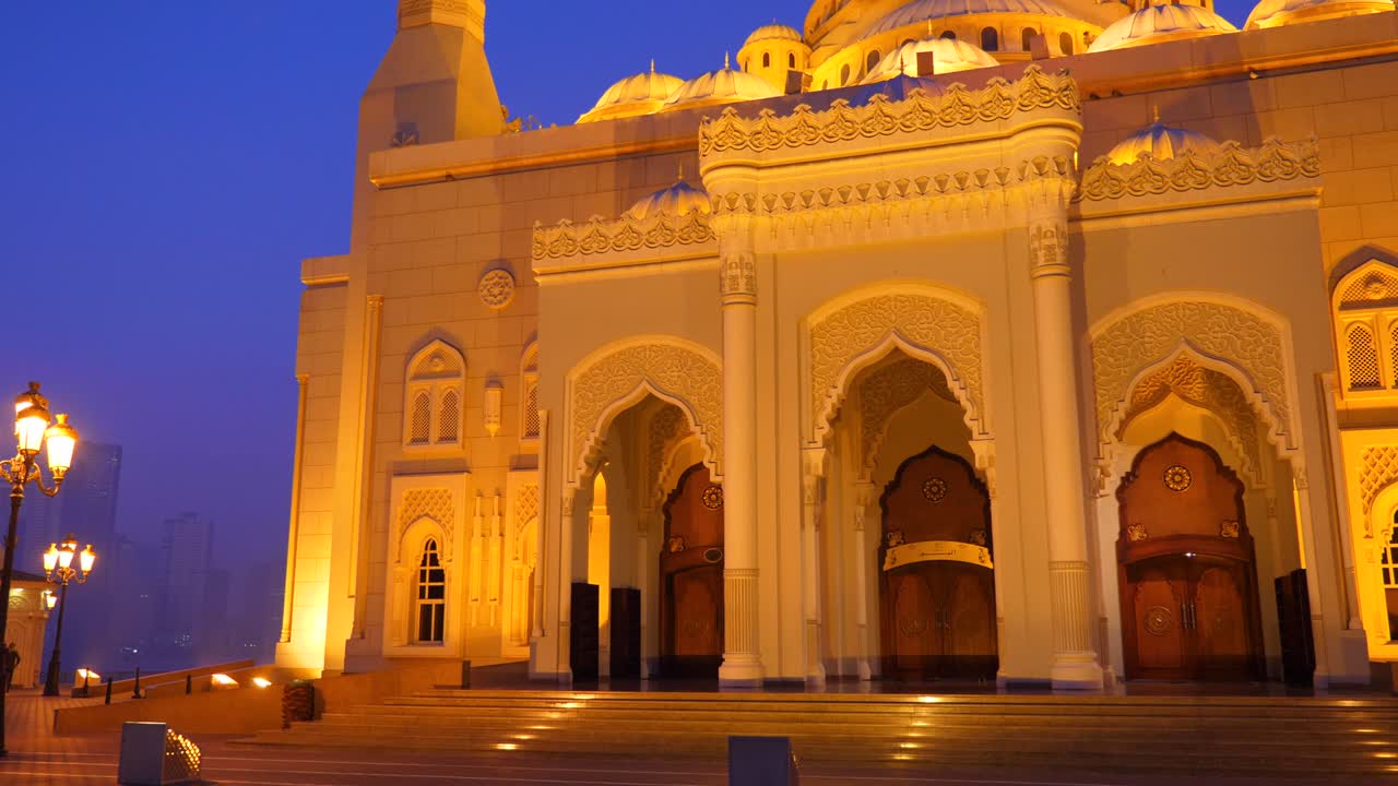 la fachada de la mezquita al noor en los emiratos de sharjah. edificio iluminado de vista nocturna.