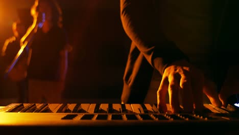 mid section of musician playing electronic piano in studio