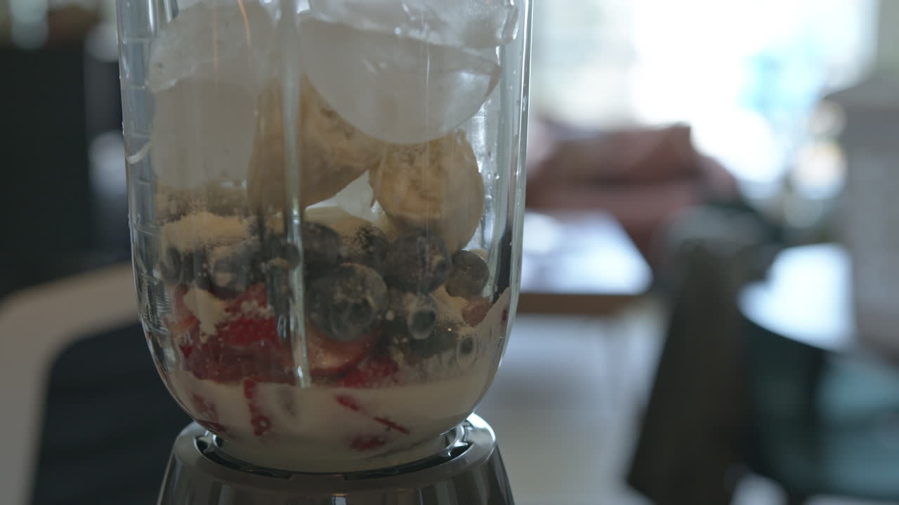 cerrar cámara lenta de frutas y hielo en una licuadora