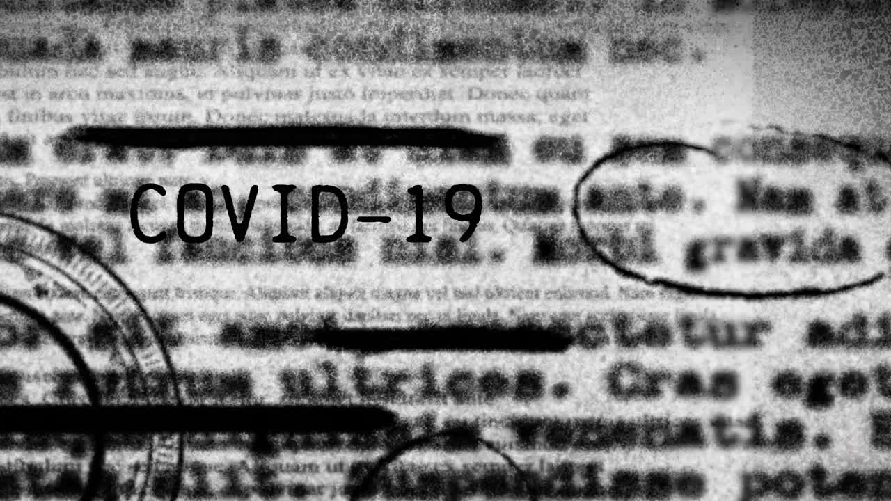 Animazione della parola Covid-19 scritta su testo sfocato con la pandemia di coronavirus in diffusione.