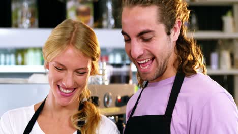 Waiter-and-waitress-smiling-at-counter