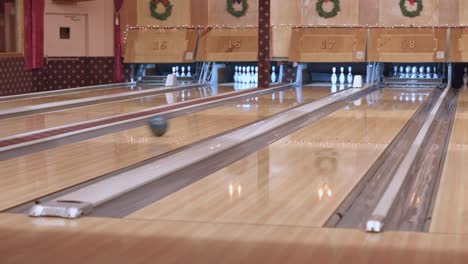 bowling alley balls striking pins in multiple lanes during christmas holiday time