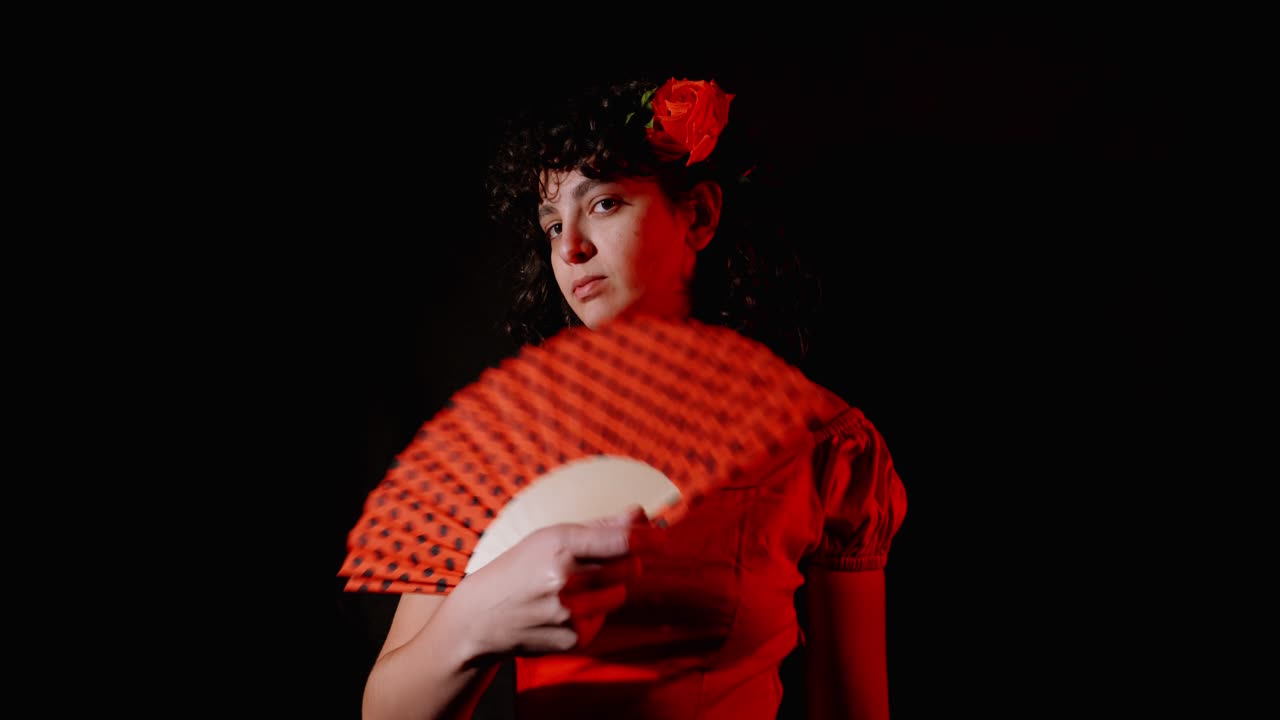 Giovane donna in abito rosso che si sventola con un ventaglio tradizionale