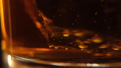 Macro-De-Whisky-Cerca-De-Cubitos-De-Hielo-Girando-En-El-Fondo-De-Un-Vaso-De-Whisky-U-Otro-Alcohol-En-Cámara-Lenta