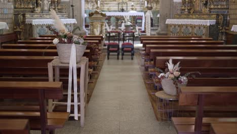 church interior with wooden pews, floral arrangements, and a view of the altar