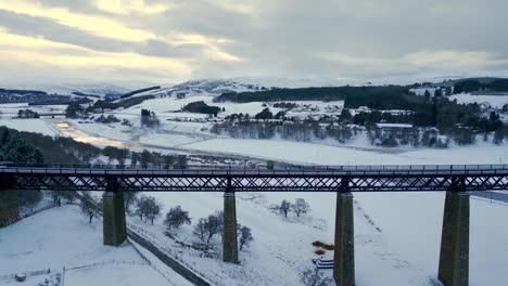 reverse-reveal-of-Findhorn-Viaduct-and-scenic-winter-landscape-covered-in-snow