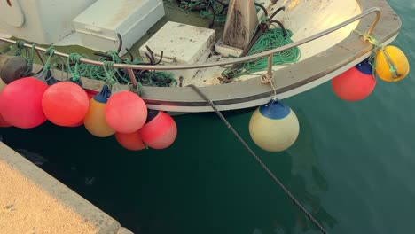 Los-Costados-Del-Barco-Están-Adornados-Con-Boyas,-Con-Vibrantes-Tonos-De-Rojo-Y-Amarillo-Que-Se-Destacan-Sobre-El-Fondo-Del-Mar,-Encarnando-La-Esencia-Vibrante-De-La-Vida-Marítima.