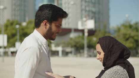 happy muslim couple performing traditional dance outside.