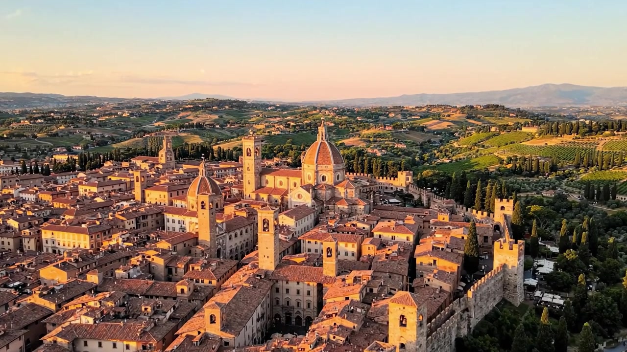 Veduta aerea di un villaggio storico italiano all'ora d'oro, che mostra una splendida architettura e paesaggi sereni nel cuore della Toscana.