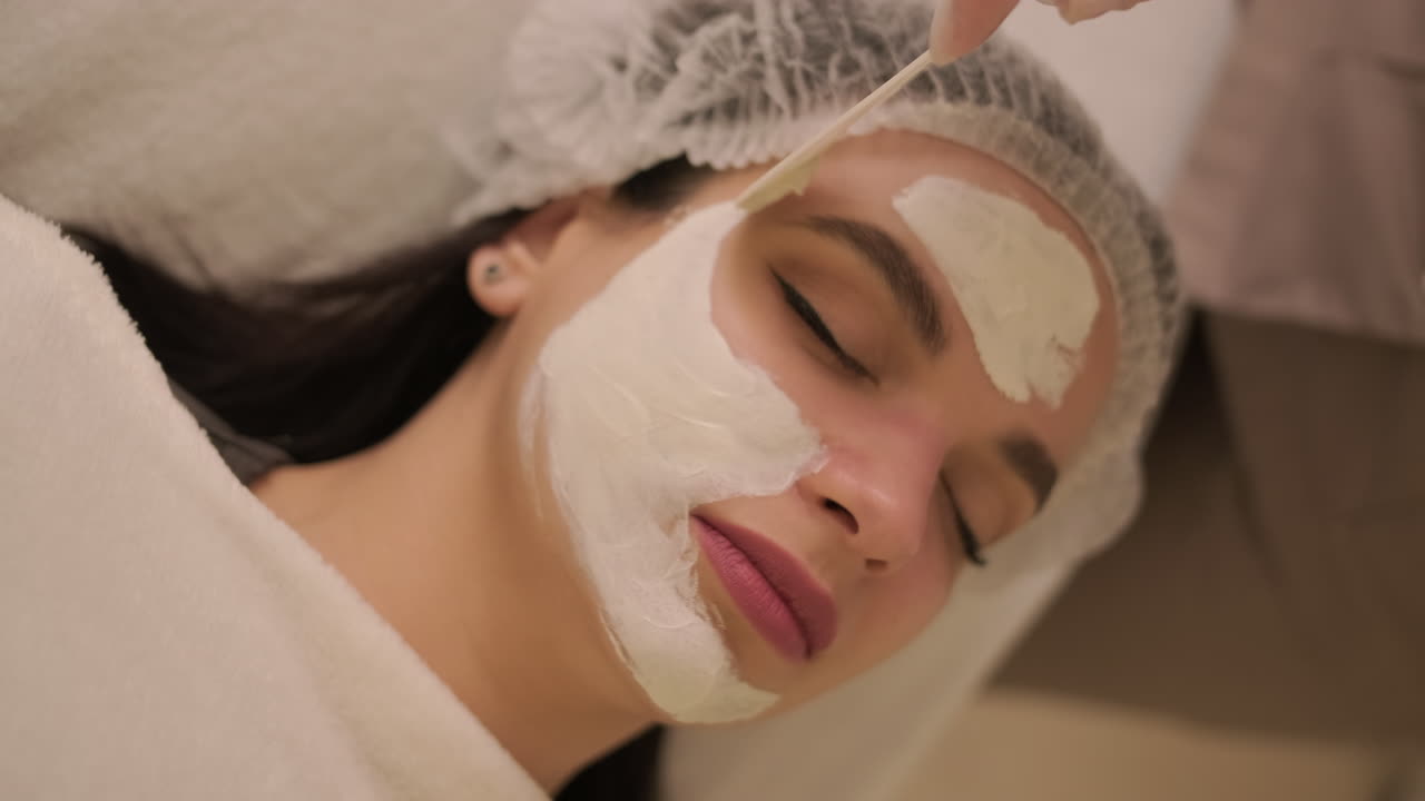 Giovane donna riceve trattamento con maschera viso in una spa