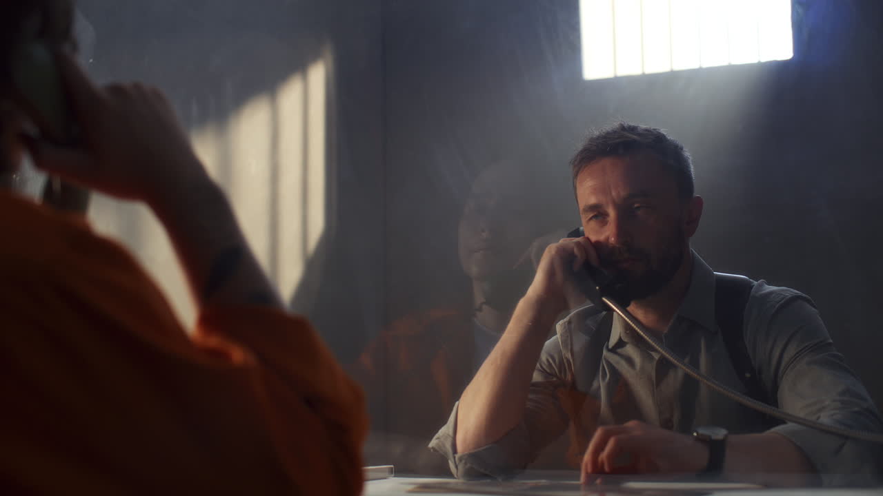 Police Officer Questioning Inmate about Crime in Prison Interrogation Room