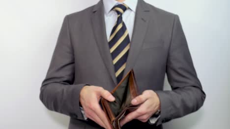el hombre de negocios muestra una billetera vacía.