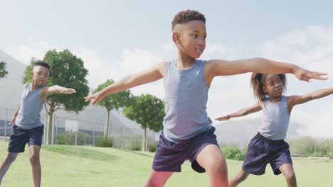 video de tres escolares afroamericanos practicando yoga de pie en una clase al aire libre