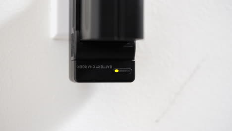 Hand-Plugging-In-DSLR-Camera-Battery-Charger-Into-Wall-Socket