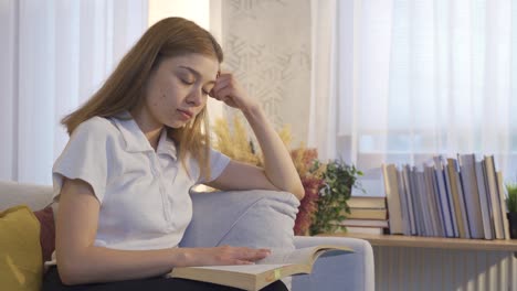 Young-girl-reading-a-book-at-home,-focused-on-the-book.