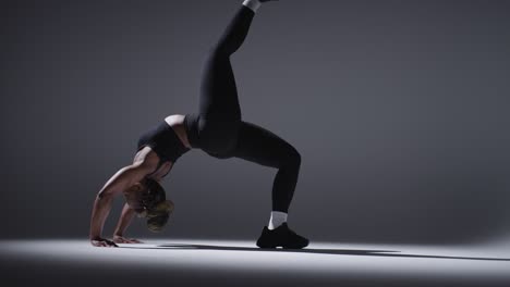 full length studio shot of woman wearing gym fitness clothing doing stretching exercise