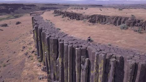 aerial pan: hiker walks on tops of rock columns, washington scablands