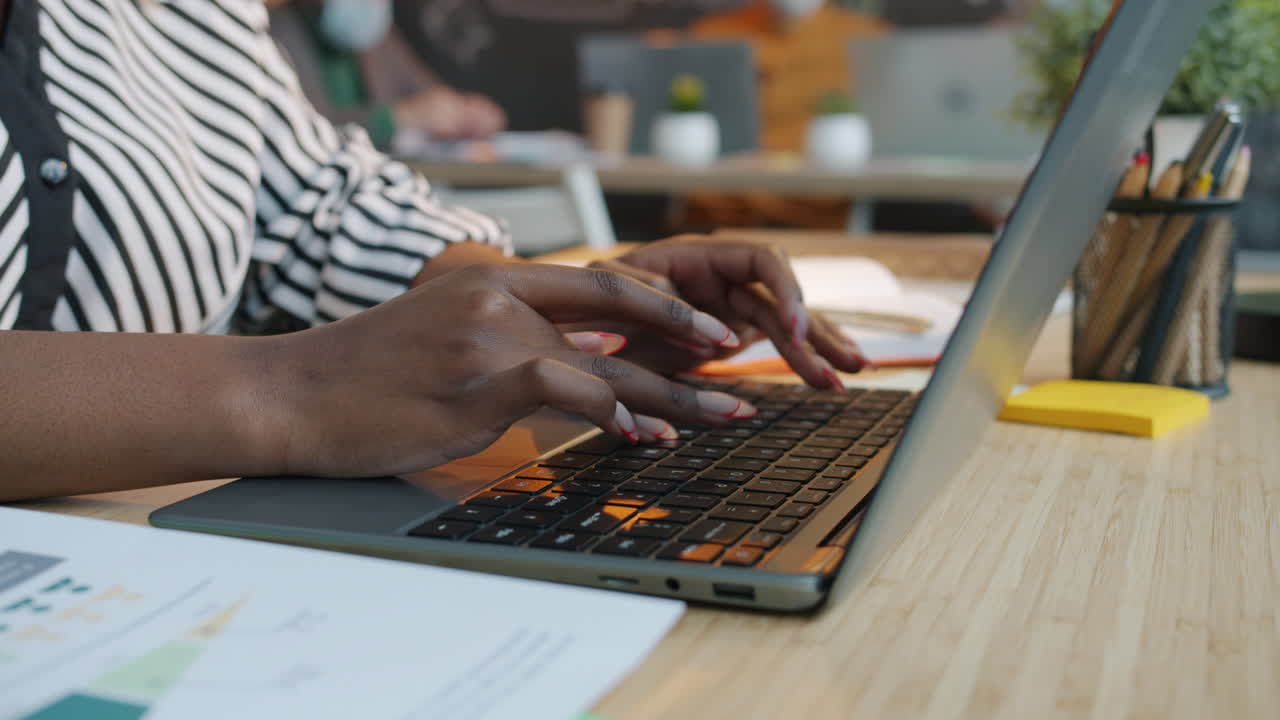 Woman Typing on Laptop in Office