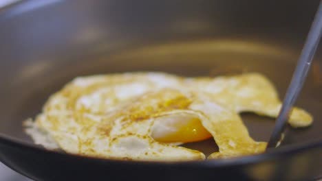 Fried Egg Turned Over in Hot Pan with Crispy Outside and Soft Golden Yolk in the Middle. High Protein Healthy Breakfast Meal Cooking Footage