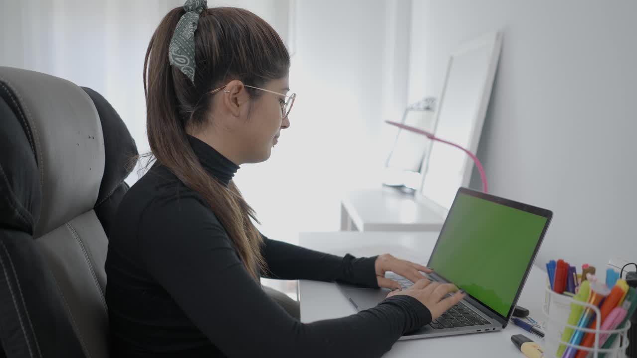 женщина, работающая на ноутбуке дома