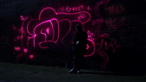 neon graffiti projection on urban wall at night