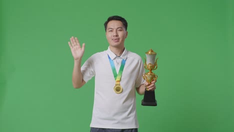 man holding a trophy and medal