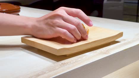 el chef coloca sushi en una tabla de madera.