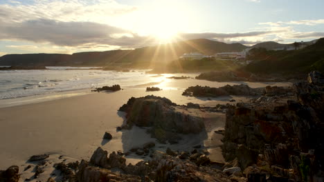 tranquil beach scene in hermanus as sunburst of sun bathes pristine coastline