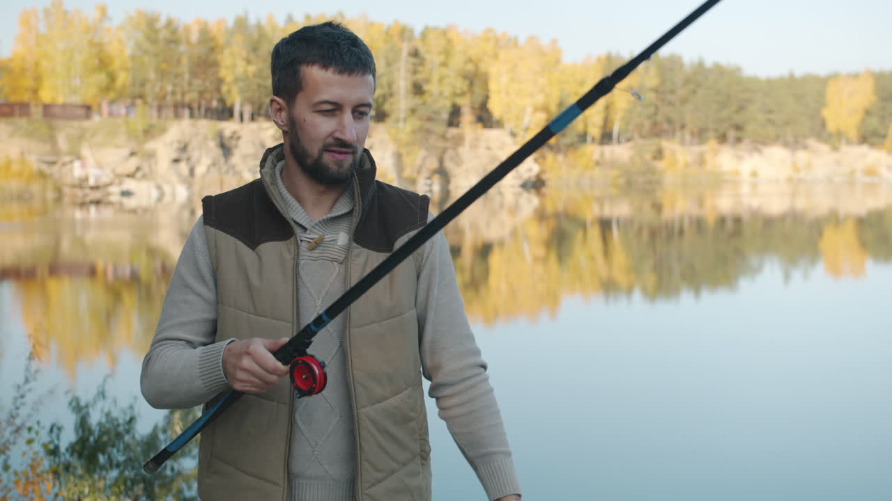 Man Fishing and Showing Catch in Autumn