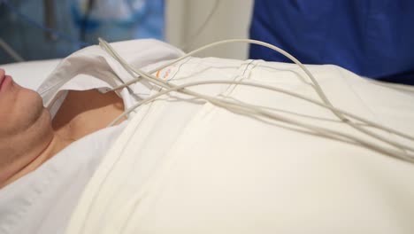 close-up of a patient's chest as a nurse applies electrodes for a heart monitor