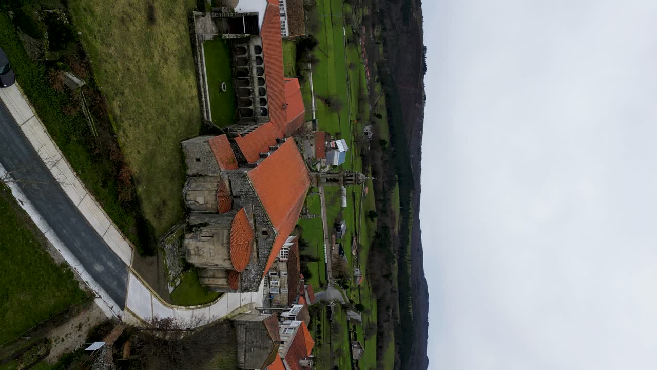 Vertical aerial rising to back courtyard of Santa Maria de Xunqueira monastery
