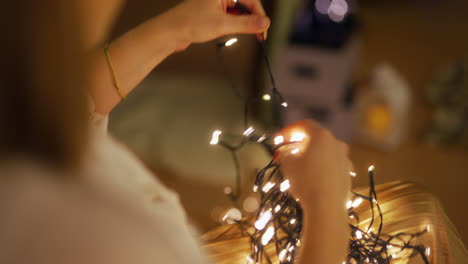 woman prepares christmas decorations in decorated house