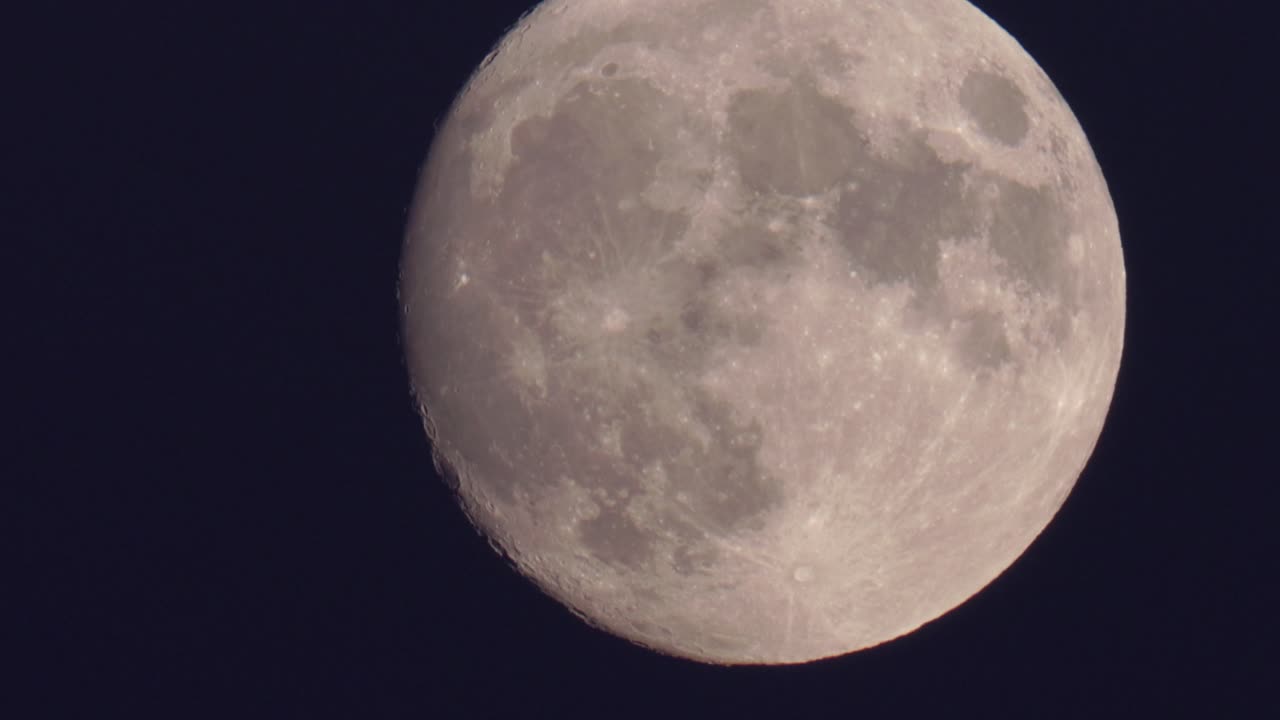 Plano detalhe de uma superlua da colheita sobre um céu escuro.