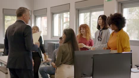 Boss distributing folders among the employees in a coworking office