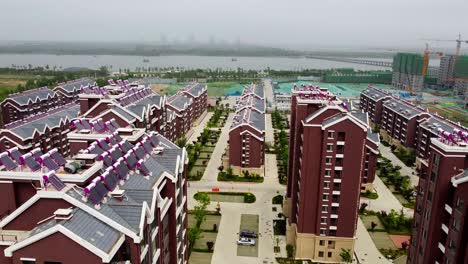 vista aérea inclinada de edificios de apartamentos de pan de jengibre con energía solar en el nuevo distrito de nanhai, china