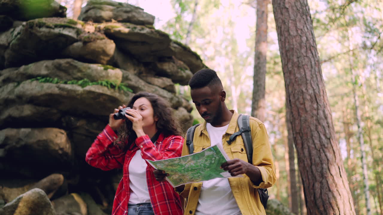 Couple Hiking and Exploring Nature with Map and Binoculars