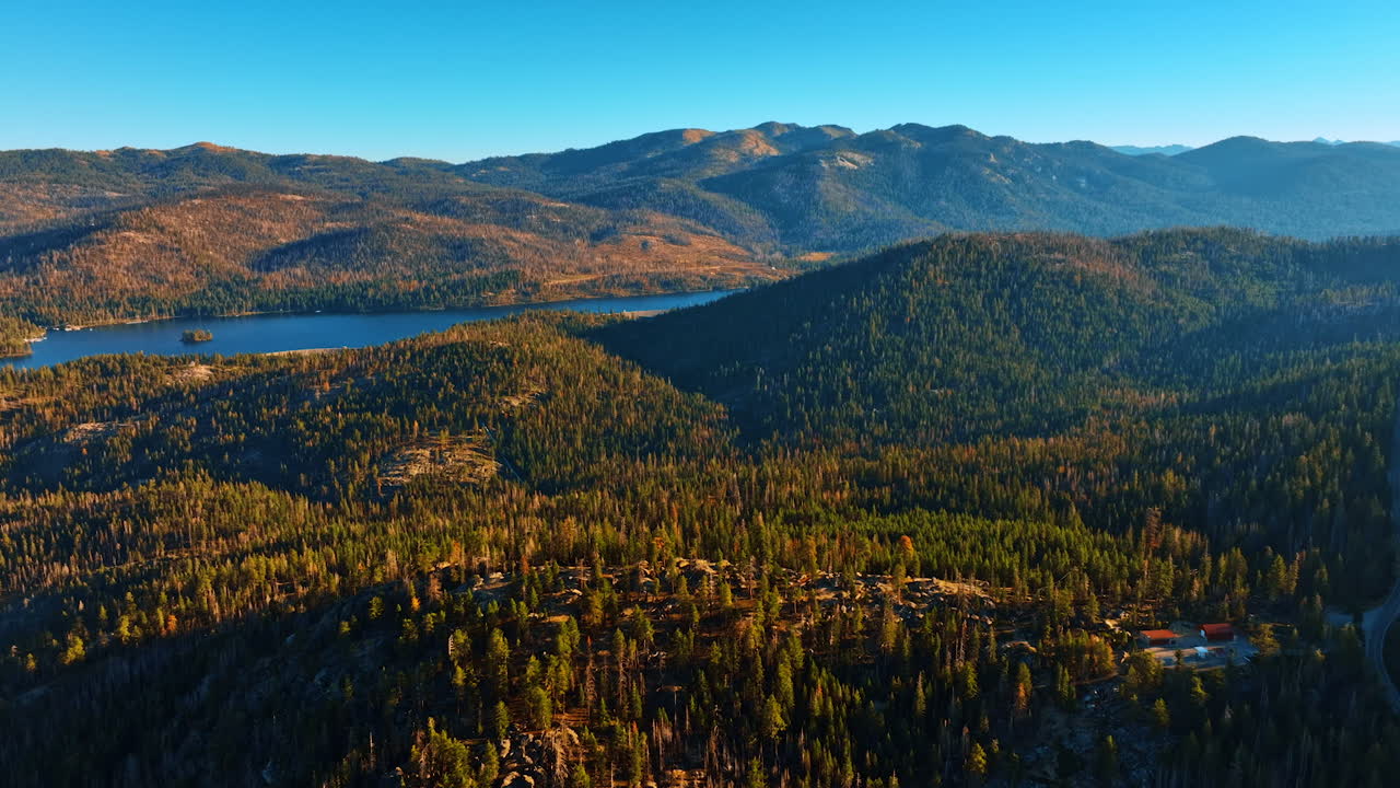 Delightful view of the mountains covered with pine trees in Sierra National Forest, USA. Calm river floating between the mountains. Aerial view.