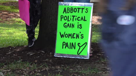 protest sign displaying the message 'abbott's political gain is women's pain'