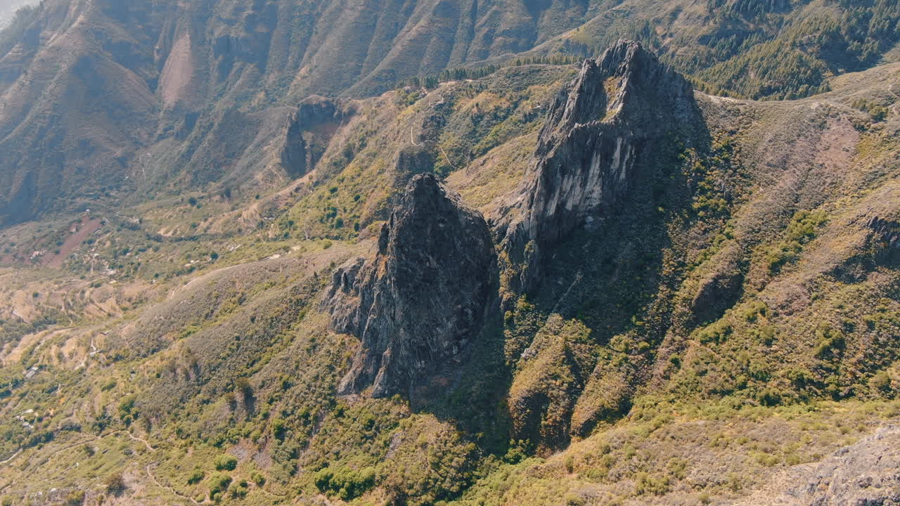 vista aérea en órbita sobre las formaciones rocosas de roque chico y roque grande en la reserva natural, en la isla de gran canaria en un día soleado