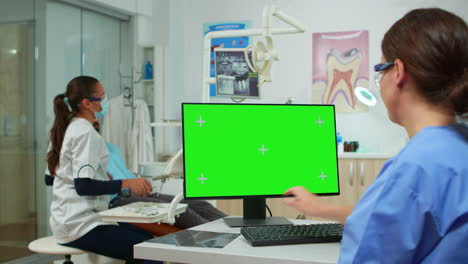 enfermera estomatóloga mirando la tableta de pantalla verde