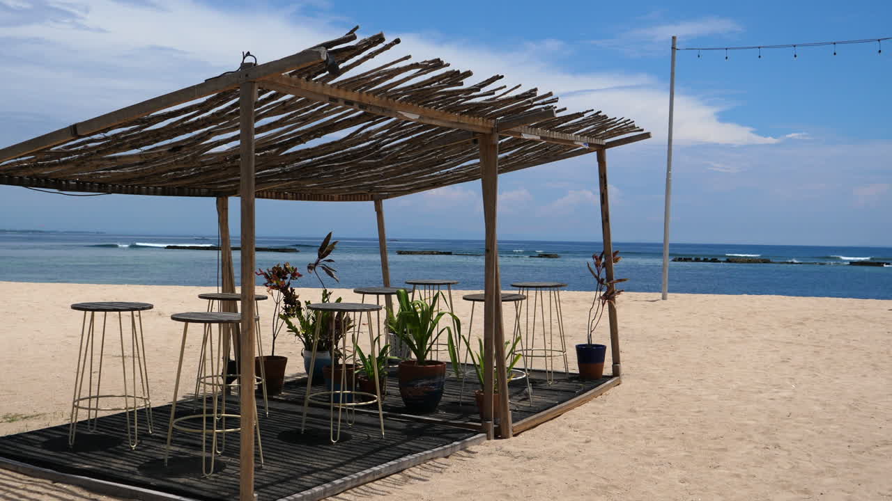 Relaxing view of shaded hut on a deserted white sand beach in Indonesia