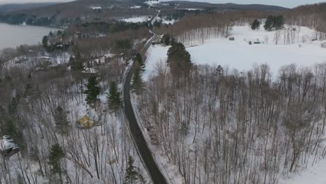 Carretera-Asfaltada-Entre-Bosques-De-árboles-Calvos-Durante-El-Invierno-En-Quebec,-Canadá