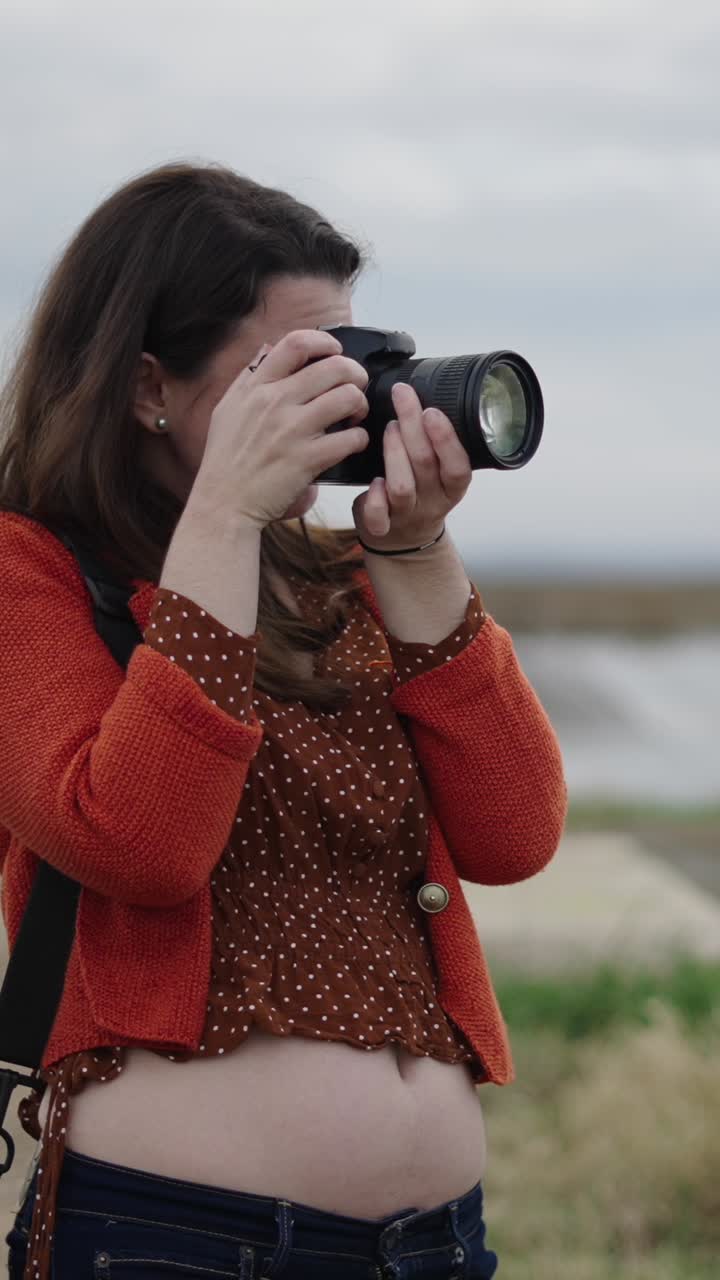 Woman taking photos outdoors with DSLR camera