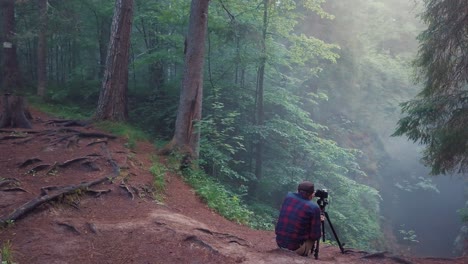 photographer capturing misty forest scene