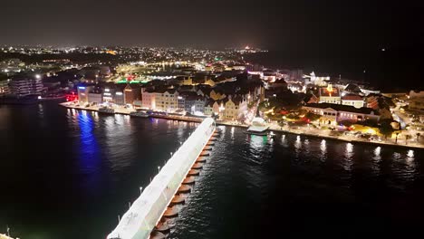 el puente de la reina emma se cierra para conectar handelskade willemstad a curaçao por la noche.