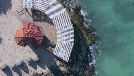 people relax in touristic village on playa dominicus beach, bayahibe in dominican republic. aerial top-down sideways