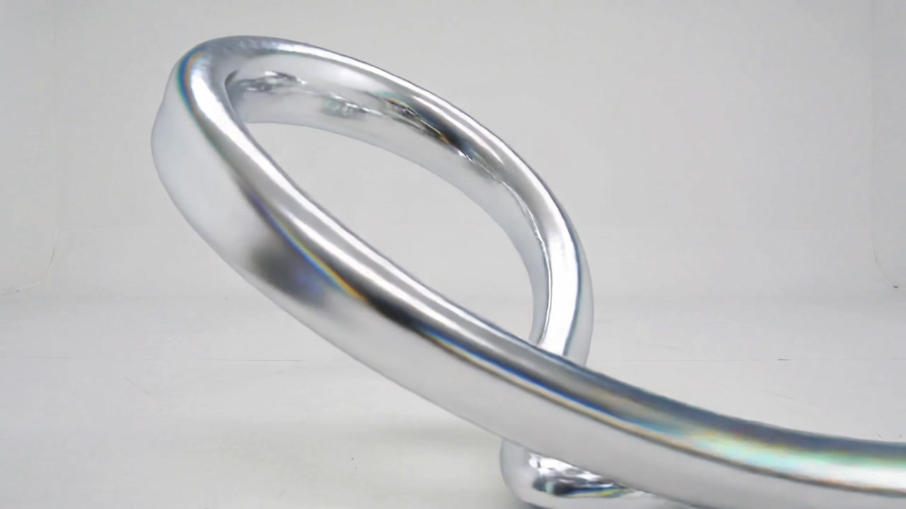 Rotating camera revealing chrome twisted-loop sculpture on white base, highlighting finish and form