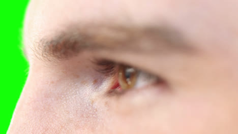 close up of a caucasian man eyes on green background